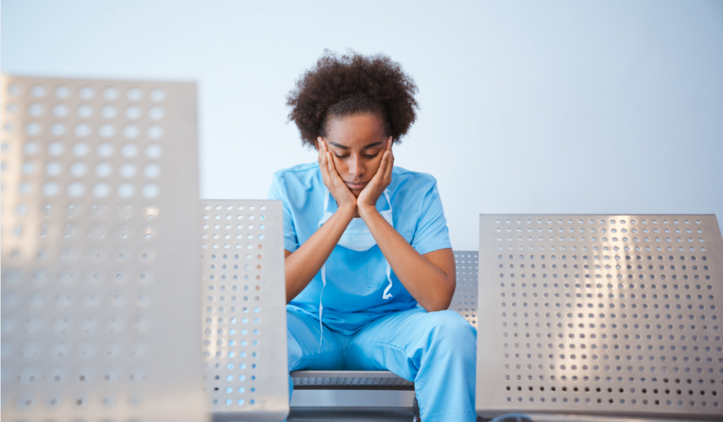 Nurse sitting quietly after a hospital shift, illustrating the real cost of nurse burnout on healthcare organizations | CHCI