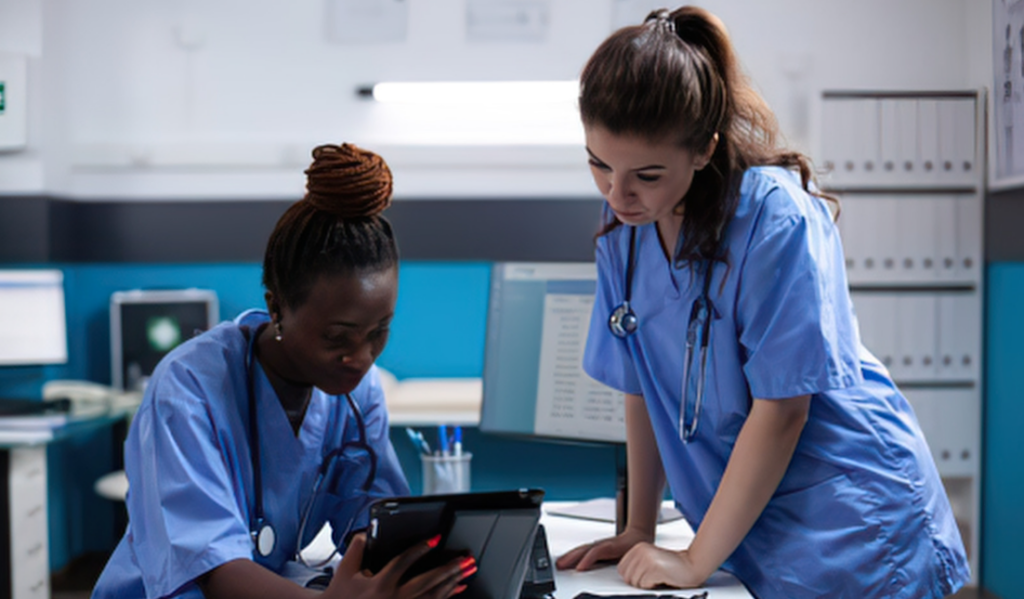 Nurse educator and registered nurse reviewing a nursing competency checklist | Creative Health Care Insight